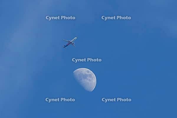 Airbus jet commercial passenger aircraft of Wizzair airlines flying in a blue sky with the moon in the background, England, United Kingdom [IBR125423489]