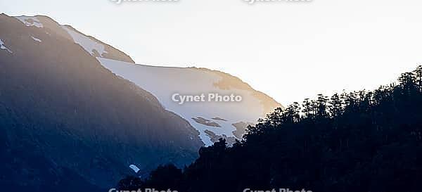 Mountains with forest and glaciated mountain peaks at sunrise, Carretera Austral, near Villa Santa Lucia, Los Lagos, Chile [IBR125423506]