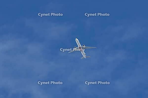 Boeing 777-300ER jet commercial passenger aircraft of Emirates airline flying in a blue sky, England, United Kingdom [IBR125423507]
