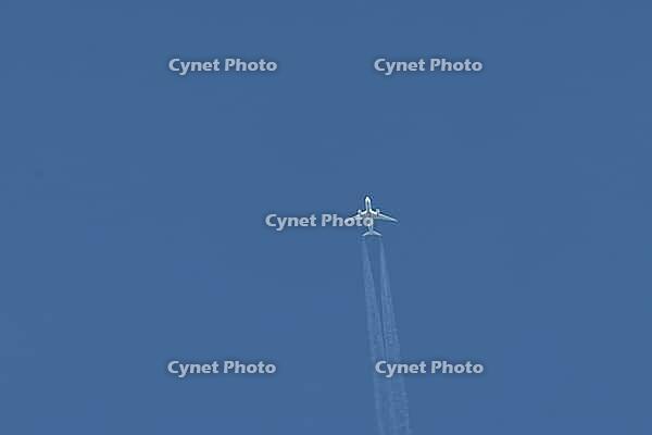 Jet commercial passenger aircraft flying in a blue sky with contrails or vapour trails behind in the atmosphere, England, United Kingdom [IBR125423512]