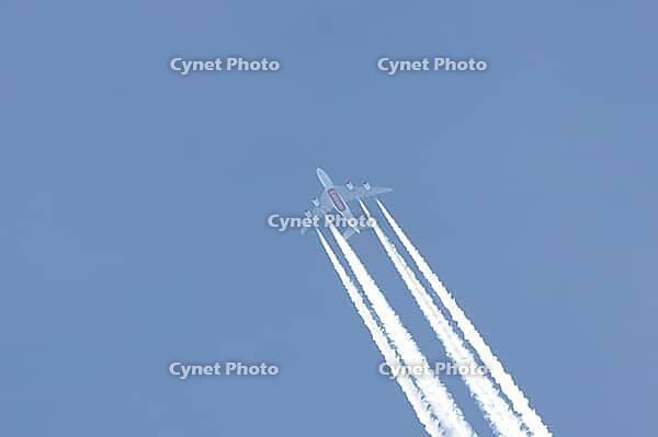 Airbus A380 jet commercial passenger aircraft of Emirates airline flying in a blue sky with contrails or vapour trails behind in the atmosphere, England, United Kingdom [IBR125423515]
