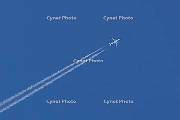 Jet commercial passenger aircraft flying in a blue sky with contrails or vapour trails behind in the atmosphere, England, United Kingdom [IBR125423516]