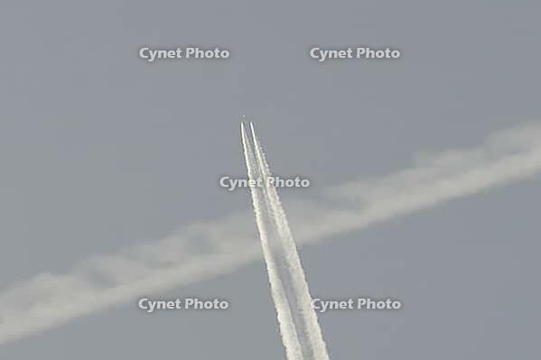 Jet commercial passenger aircraft flying in a blue sky with contrails or vapour trails behind in the atmosphere, England, United Kingdom [IBR125423518]