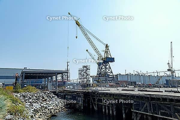 Industrial scene with heavy machinery and structures at a waterfront facility, indicating ongoing development and maritime activity, North Vancouver, BC, Canada [IBR125424514]