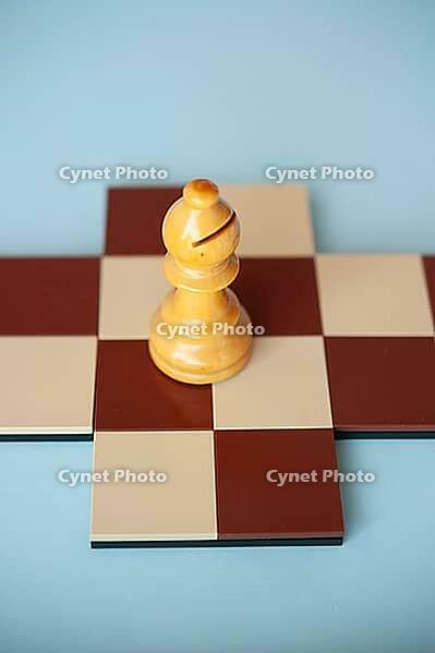 A single pawn stands on a small chessboard against a light blue background [IBR125424550]