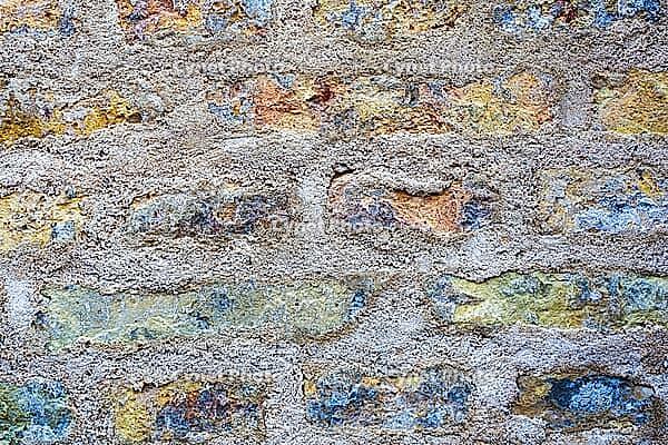 Distressed brick wall with rough mortar, creating a rugged abstract background texture [IBR125424555]