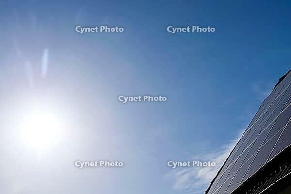 Solar panels on a roof generating clean energy under a bright blue sky [IBR125436238]