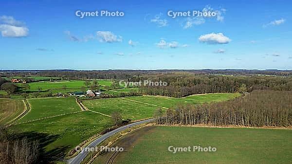 Aerial view showing German countryside with agricultural land, forests, and farm building [IBR125436241]