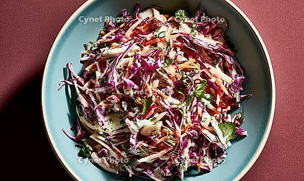 Fresh coleslaw in blue bowl. Red cabbage, carrots, green herbs. Bright colors, appetizing dish. Top-down view, rustic background, AI generated [IBR125446415]