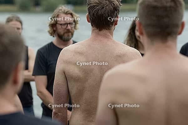 Vulnerable men gathering in a supportive circle by a lake for emotional healing, psychological growth, somatic body awareness, mindful brotherhood, an exposed bare back stands centered amidst attentive listeners as a metaphor for deep emotional transparen [IBR125446418]