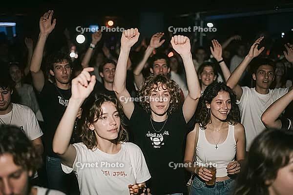 Ecstatic youth crowd dancing with raised hands at live music concert inside vibrant nightclub, celebrating freedom, community and nightlife culture, young people immersed in rhythmic euphoria, fists raised into the air create a powerful symbol of unity, c [IBR125446438]