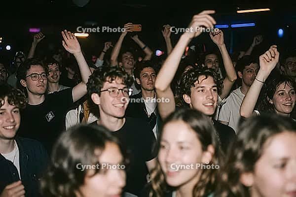 Youthful crowd celebration and collective euphoria during a live concert event, young people enjoying nightlife party atmosphere, raised arms moving rhythmically to musical beats within a dark club hall, smiling faces expressing pure ecstasy and authentic [IBR125446463]