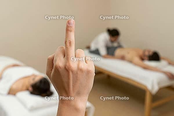 Rebellious middle finger gesture before relaxing spa treatment, rejecting wellness culture, disruptive nonverbal provocation, stress relief defiance, stark conceptual contradiction between visceral aggression and meditative tranquility, an anonymous hand  [IBR125446485]