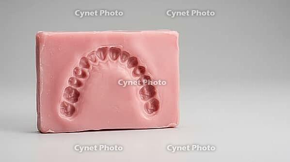 Close-up of a fresh bite indentation pressed into pale pink dental impression wax before casting, pale grey background, forensic odontology procedure photography, AI generated [IBR125446501]