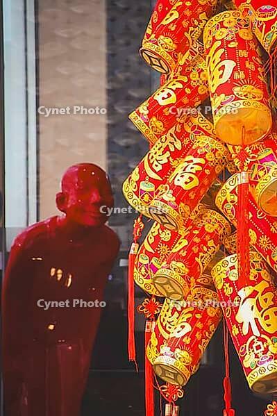 Chinese red decorative lanterns hang next to a red figure, evoking a festive mood during the celebration of Lunar New Year in Hong Kong [IBR125448814]