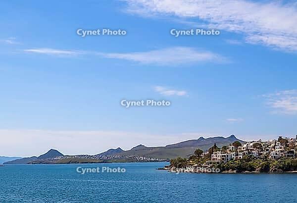 Bitez coastal landscape with traditional white architecture on green hills overlooking the tranquil blue waters of the Aegean Sea [IBR125462064]