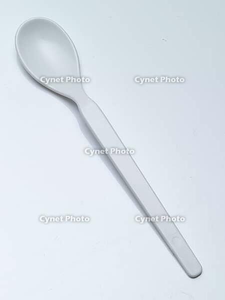 White children's spoon against a white background, studio shot [IBR125462069]