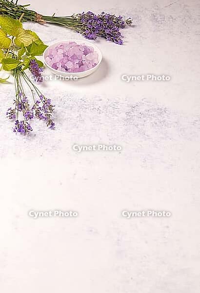 Lavender bath salts in a bowl with fresh lavender sprouts and green leaves, symbolizing natural spa treatments, aromatherapy, and wellness for relaxation [IBR125462081]