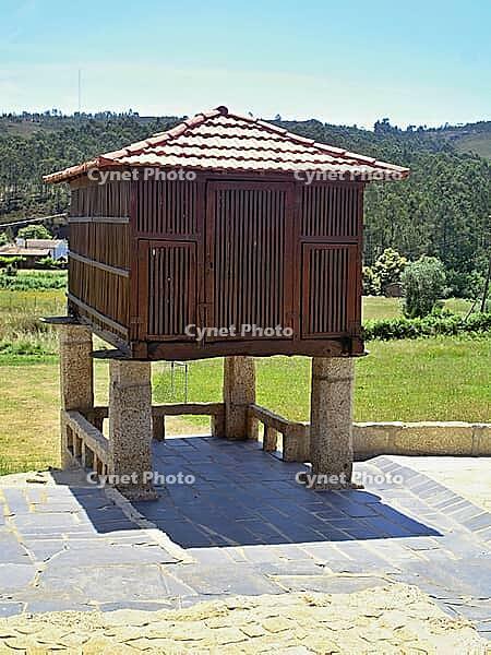 Historic espigueiro granary standing in a rural field under a blue sky, demonstrating Portugal's agricultural heritage [IBR125462091]