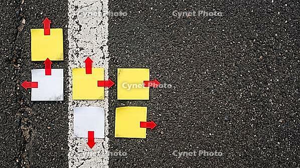Top view of blank sticky notes with red arrow markers pointing different ways on dark asphalt beside faded white lane line, crossroads concept, studio shot, AI generated [IBR125472276]