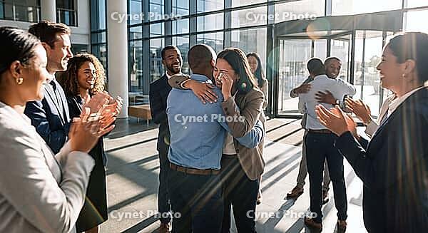 Emotional business team celebration in modern glass corporate lobby, diverse colleagues applauding and embracing tearful woman after promotion success, authentic human connection softening rigid corporate architecture, sunbeams flooding through high windo [IBR125472282]
