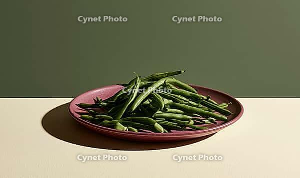 Fresh green beans on a pink plate. Plate sits on a light surface. Background is muted green. Beans appear crisp and vibrant, AI generated [IBR125472302]