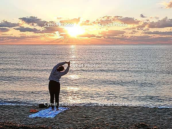 A woman does yoga at sunrise on Tortoli beach, Sardinia, 29.09.2026, Tortoli, Italy [IBR113453106]