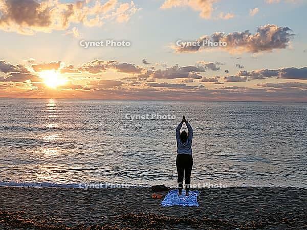 A woman does yoga at sunrise on Tortoli beach, Sardinia, 29.09.2026, Tortoli, Italy [IBR113453107]