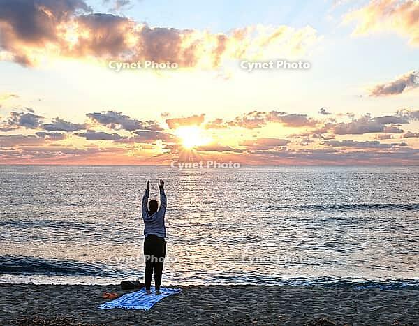 A woman does yoga at sunrise on Tortoli beach, Sardinia, 29.09.2026, Tortoli, Italy [IBR113453109]