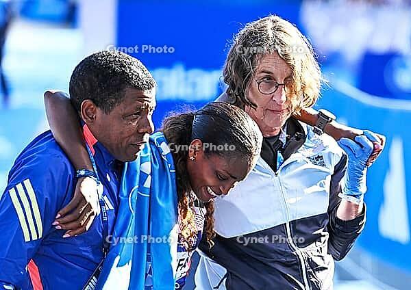 27 September 2026, Athletics: BMW Berlin Marathon 2026, from left: Tigst Assefa (ETH 2:11:04) crosses the finish line, exhausted, and is supported by a team at the 2026 BMW BERLIN MARATHON [IBR113453124]