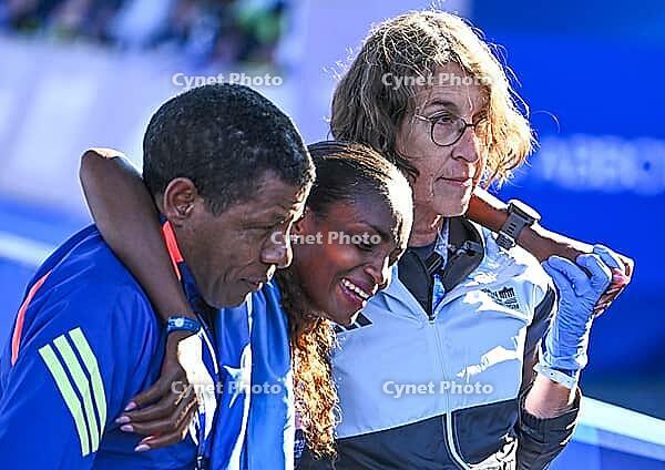 27 September 2026, Athletics: BMW Berlin Marathon 2026, from left: Tigst Assefa (ETH 2:11:04) crosses the finish line, exhausted, and is supported by a team at the 2026 BMW BERLIN MARATHON [IBR113453159]