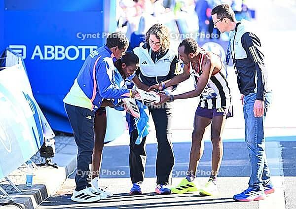 27 September 2026, Athletics: BMW Berlin Marathon 2026, from left: Tigst Assefa (ETH 2:11:04) crosses the finish line, exhausted, and is supported by a team at the 2026 BMW BERLIN MARATHON [IBR113453178]