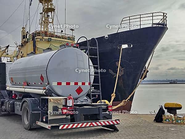 Fuel tanker parked next to a cargo ship at the port of Montevideo, highlighting maritime logistics and industrial transport [IBR125492348]