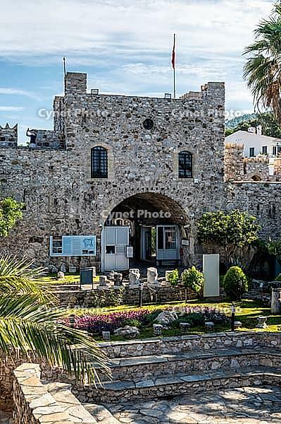 Marmaris, Turkey, 19.06.2026. Historical medieval fortress building featuring a stone arch entrance gate with ancient ruins and a blooming garden on a sunny summer morning in Marmaris resort [IBR125492357]