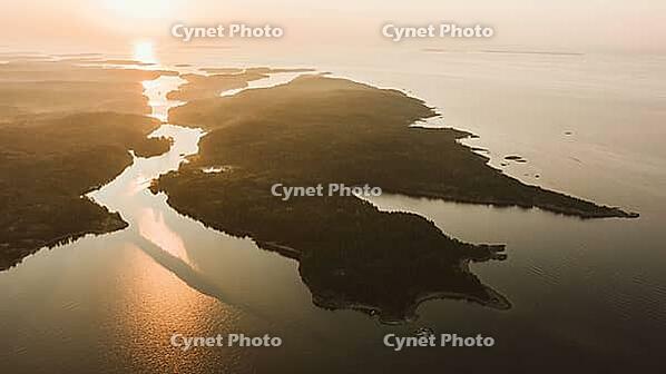 Stunning aerial view of multiple islands surrounded by calm waters at sunrise, highlighting natural beauty and tranquility. Ladoga skerries at dawn, northern landscape [IBR125492369]