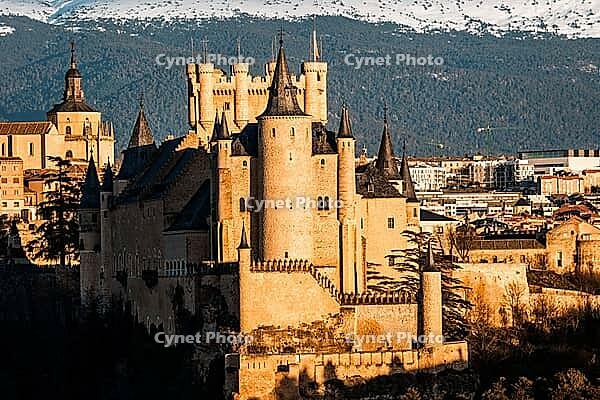 A beautiful view of the Alcazar of Segovia, Spain, with the Guadarrama mountain range visible in the background on a sunny day [IBR125492415]