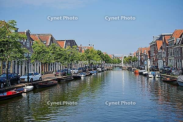 Alkmaar, Netherlands - 12th century August 2020: Boats moored in a wide canal in the middle of the residential area of Alkmaar, Netherlands [IBR125492420]