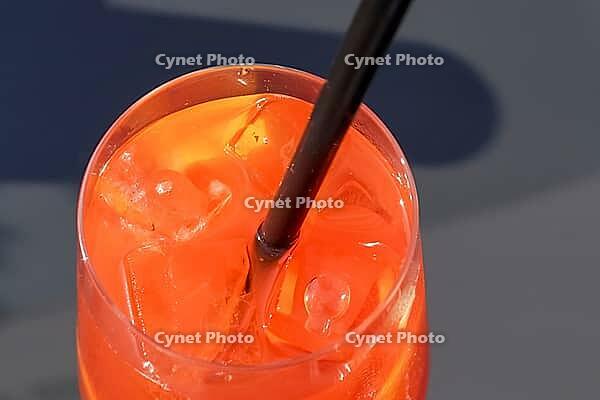 Refreshing orange summer cocktails with ice against a blue sky background [IBR125501606]