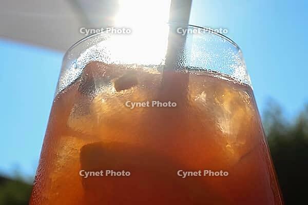 Refreshing orange summer cocktails with ice against a blue sky background [IBR125501644]