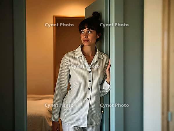 Young woman in pajamas looking away thoughtfully while exiting her bedroom after waking up in the morning, AI generated [IBR125502132]