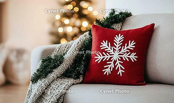 Simple red pillow with white snowflake embroidery on a light gray sofa, AI generated [IBR125502199]