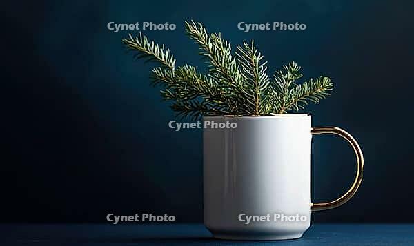 White mug with a golden handle and a sprig of fir on top, set against a deep blue background with soft natural light, AI generated [IBR125502207]