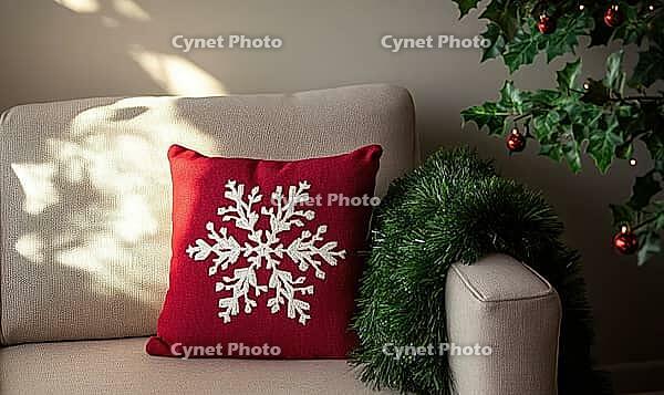 Simple red pillow with white snowflake embroidery on a light gray sofa, AI generated [IBR125502221]
