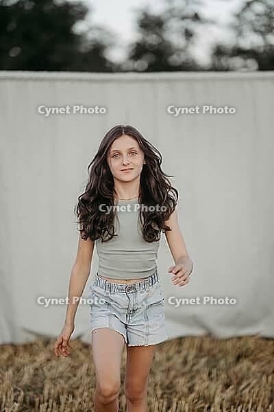 Brown-haired girl, 11, in a cornfield against a beige background [IBR125521109]