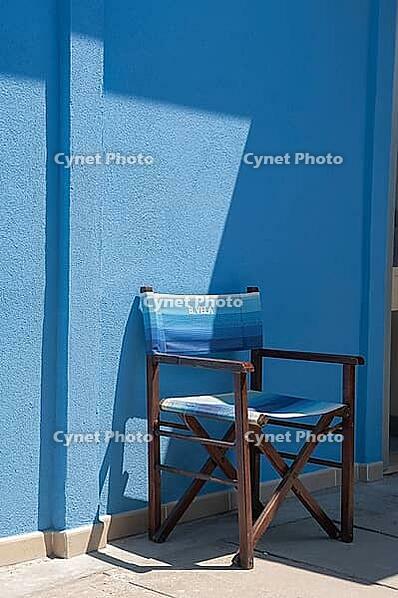 Wooden folding chair standing on blue house wall, Punta Marina, Ravenna, Emilia-Romagna, Italy [IBR125521117]