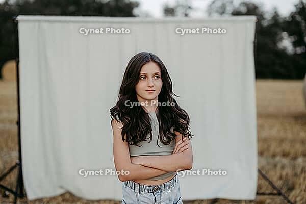 Brown-haired girl, 11, in a cornfield against a beige background [IBR125521129]