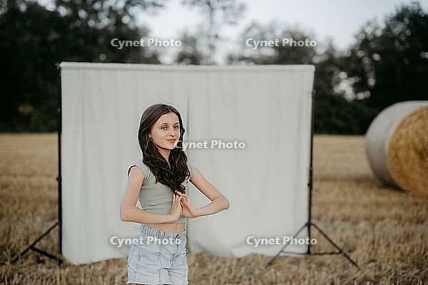 Brown-haired girl, 11, in a cornfield against a beige background [IBR125521138]