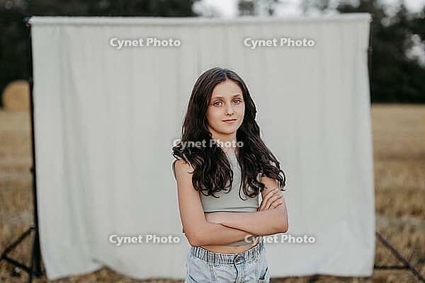Brown-haired girl, 11, in a cornfield against a beige background [IBR125521145]