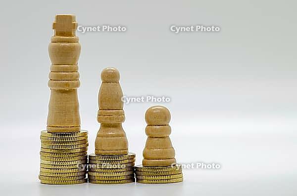 Wooden chess pawn and stacked coin arrangement on clean background isolated, representing financial strategy and value growth [IBR125527028]