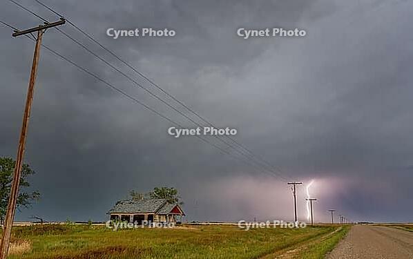 Lightning illuminates the prairie near an abandoned farmhouse during a powerful thunderstorm [IBR125527057]